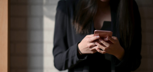 Cropped shot of young businesswoman using smartphone