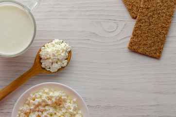 A glass bottle with kefir and kefir grains with bread rolls on the