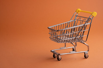 Turned pushcart empty on orange background, Black Friday concept.