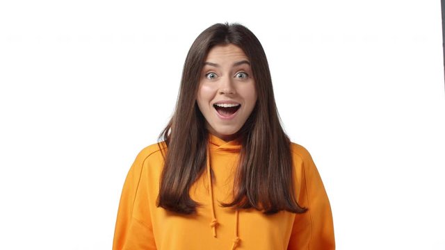 Happiness, food and people concept. Slow-motion lovely brunette caucasian woman in orange hoodie, hold hands together, drop jaw amazed, waiter brought food, lick lips, see tasty, delicious meal