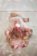 model laying on floor double exposed with flowers