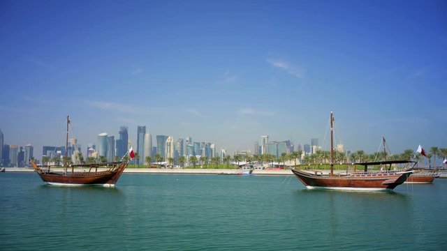 Two dhow boats with Doha West Bay in the background