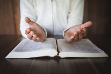 A young woman prayed with the palm upside down. Popular scriptures are considered sacred blessings of God, the concept of spirituality and Christian worship and praise in the divine power of God.