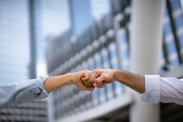 Businessmen making hands fist bump in the city for team teamwork and partnership business success...