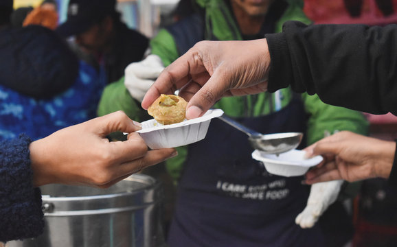 Vendor serving gol gappa at market stall