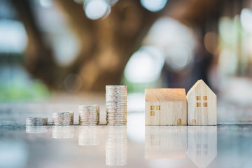 Wood house model and row of coin money on white background, Real Estate market, Trading Estate,...