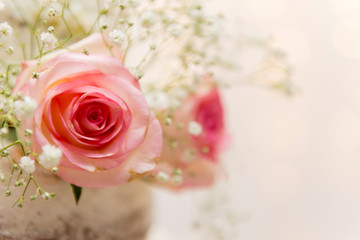 Close up of beautiful white tree tier cake with fresh flowers with fairly light and lanterns glowing in the background. Selective focus. Copy space.