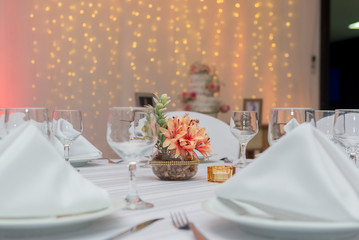 Crystal bowls, fabric napkins and decorative flowers in beautiful vase on a dining table next to a candle. Simple decoration of wedding anniversary. Text area. Copy space Selective focus.