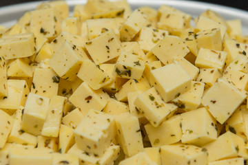 Close up of diced cheese to be served at party. Cheese seasoned with oregano, salt and olive oil. Delightful to be enjoyed and accompanied by beer. Selective focus.