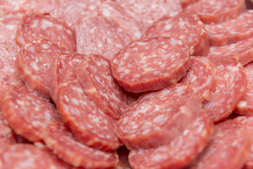 Close up of sliced salami to be served at parties or friends gatherings. A delicious snack to eat with friends and family. Selective focus.