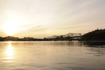 sunset on the river with bridge in the distance
