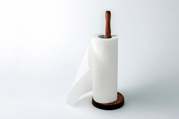 Paper towels on a wooden holder on a wooden desk