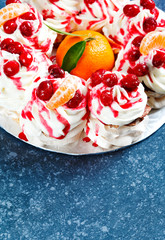 Meringue Pavlova Wreath Cake with Whipped Cream, cranberry and tangerine, top view, copy space. Winter dessert.