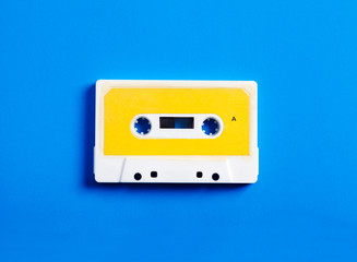 Retro cassette tape on blue background, top view.