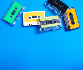 Retro cassette tapes on blue background, top view, copy space