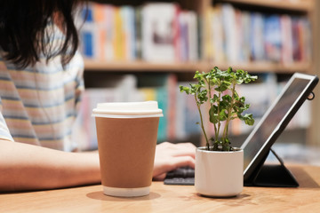 Asian working women used coffee paper cup and working in co working space
