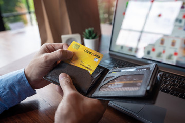 Man paying with credit card and entering security code for online shopping making a payment or purchasing goods on the internet with laptop computer, online shopping concept
