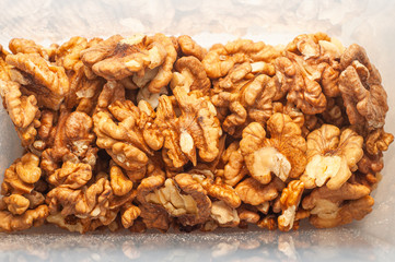 Close-up peeled walnut kernels in a plastic storage container