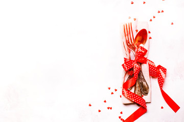 Table setting for Valentines Day, set of cutlery, red ribbon and sweet hearts, copy space, top view