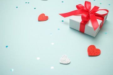 Holiday gift box with bow. Birthday surprise, Valentines day present with red satin tape close up. Copy space.