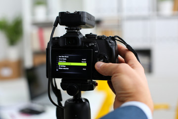 Male arms in suit mount camcorder to tripod