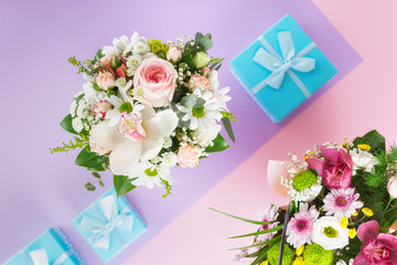Top view flower bouquet on purple background with presents flat lay