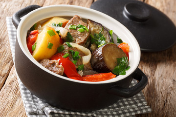 Chanakhi is a traditional Georgian dish of lamb stew with tomatoes, aubergines, potatoes, greens and garlic close-up. Horizontal