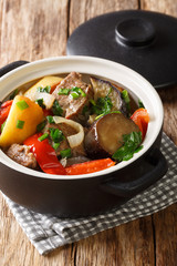 Caucasian cuisine Chanakhi of meat with vegetables in a pot close-up on the table. vertical