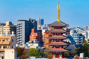 Japan. Tokyo. Asakusa temple on the background of buildings. Red Tower Of Sensoji Temple. Guide to the streets of Asakusa. Tokyo Attractions. Japanese architecture. Iconic buildings of Japan.