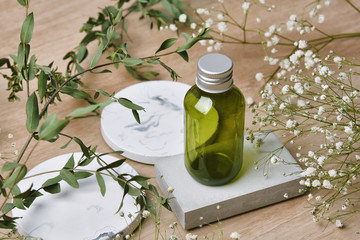 Cosmetic bottle containers packaging with green herbal leaves, Blank label for organic branding mock-up, Natural skincare beauty product concept.