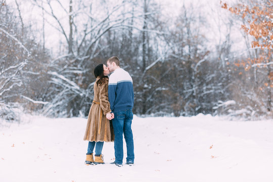 Love Valentine Concept. people, season, love and leisure concept - happy couple hugging and kissing outdoors in winter. Romantic couple in love feeling happiness romance Valentine . love copy space.