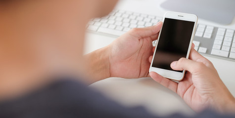  Cropped shot view of man hands holding smart phone with blank copy space screen for your text message or information content, female reading text message on cell telephone during in urban setting. 