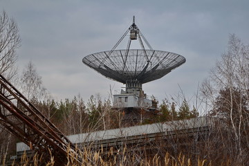 Old radio antenna in the forest. Astronomy and space research.