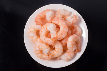 Top view of bowl with boiled peeled shrimps isolated on white