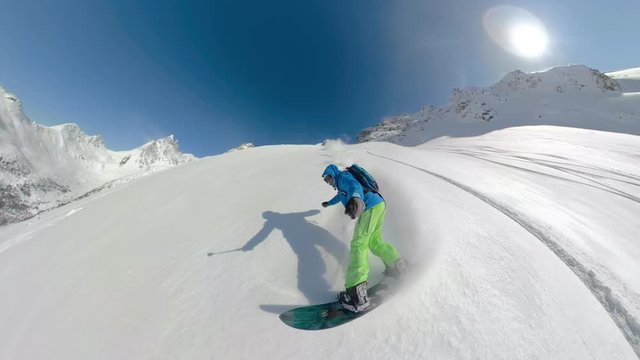 SELFIE: Extreme male snowboarder shreds fresh powder in the stunning Canadian mountains. Active tourist goes shredding champagne powder during a heliboarding trip in picturesque British Columbia.