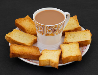 Indian Masala Chai or Morning Tea Served With Toast on Black Background