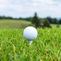 Golfball abschlagsbereit auf einem Tee 