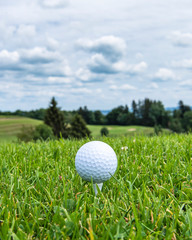 Golfball abschlagsbereit auf einem Tee 