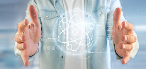 Businessman holding an atom icon surrounded by data