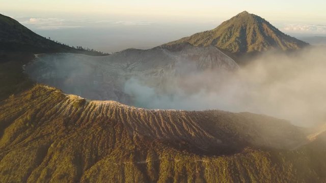 Aerial View of Volcano Crater With Smoke and Acidic Lake During Golden Hour 