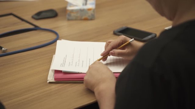 Person taking notes at a language class. They're learning how to speak and write in English, their main language is Spanish.