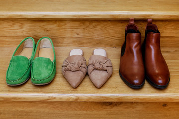 A pair of moccasins, mule shoes and Chelsea boots on the stairs.