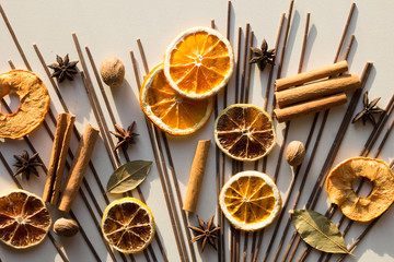 Top view of dry pieces of lemon, orange and apples, cinnamon sticks, bay leaves, nutmegs and star...