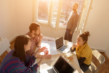 Team made of young architects in the sunny office.