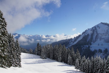 Fototapeta na wymiar Alpen Panorama im Winter mit Sonne Schnnee und blauem Himmel
