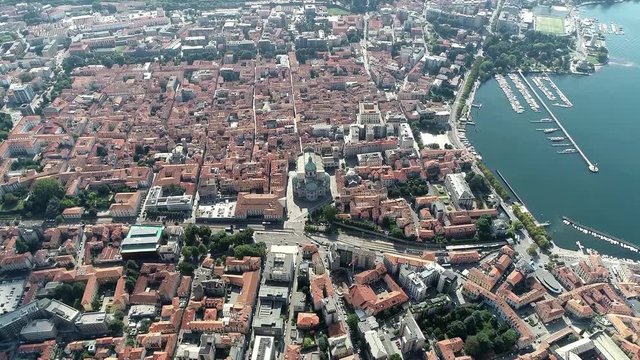 High altitude aerial view of Como a city and comune in Lombardy Italy its proximity to Lake Como and to the Alps has made it a popular tourist destination also showing the famous Duomo cathedral 4k