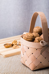 Healthy organic walnuts in a straw basket. Close-up on a white background.