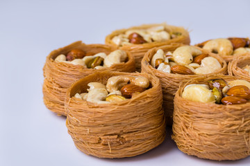 Obraz premium Oriental sweets, baklava, Turkish delight with almonds, cashews and pistachios on plates.