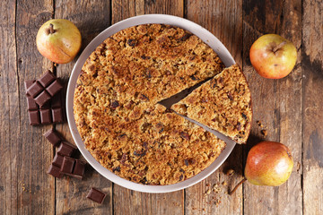 crumble with pear and chocolate on wood background
