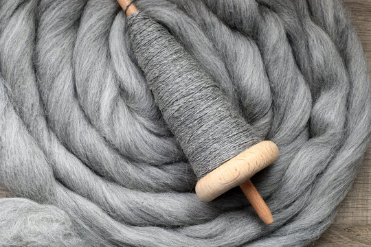 Handspindel auf grauem Kammzug zum Spinnen